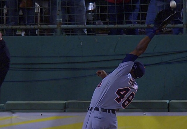 Torii Hunter attempts to steal a home run from David Ortiz before flipping over the wall in right field.