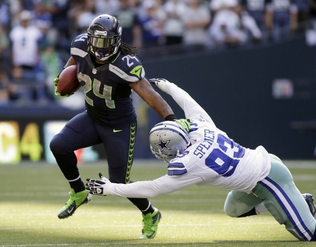 Marshawn Lynch breaks tackle against the Dallas Cowboys' defender Spencer.  Reuters