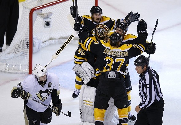 The Boston Bruins celebrate their win as Pittsburgh Penguins' Sidney Crosby 