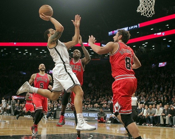Brooklyn Nets guard Deron Williams drives for a layup past Chicago Bulls forward Carlos Boozer 