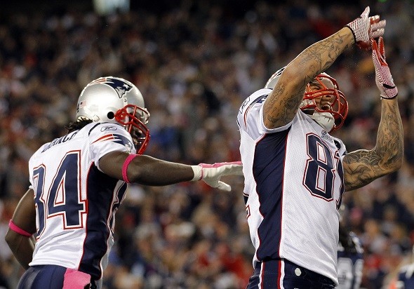New England Patriots tight end Aaron Hernandez (R) celebrates his touchdown against the Dallas Cowboys while being congratulated by Deion Branch