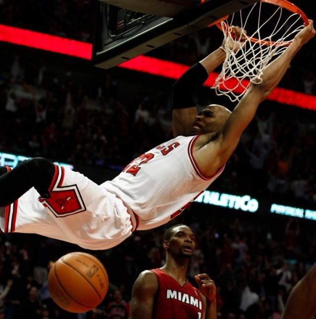 Chicago Bulls' Taj Gibson dunks the ball over Miami Heat's Chris Bosh (rear) 