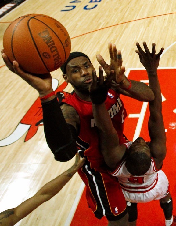 Miami Heat's LeBron James (L) goes to the basket against Chicago Bulls' Luol Deng