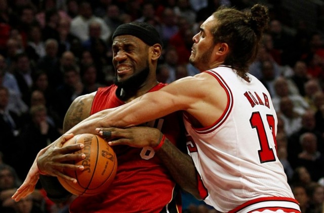 Miami Heat's LeBron James (L) is fouled by Chicago Bulls' Joakim Noah 
