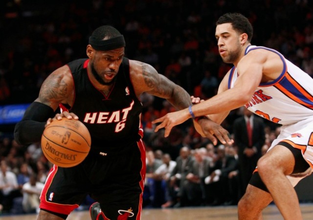 Miami Heat's LeBron James (L) drives past New York Knicks' Landry Fields
