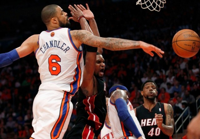 New York Knicks' Tyson Chandler (L) blocks the ball away from Miami Heat's Chris Bosh