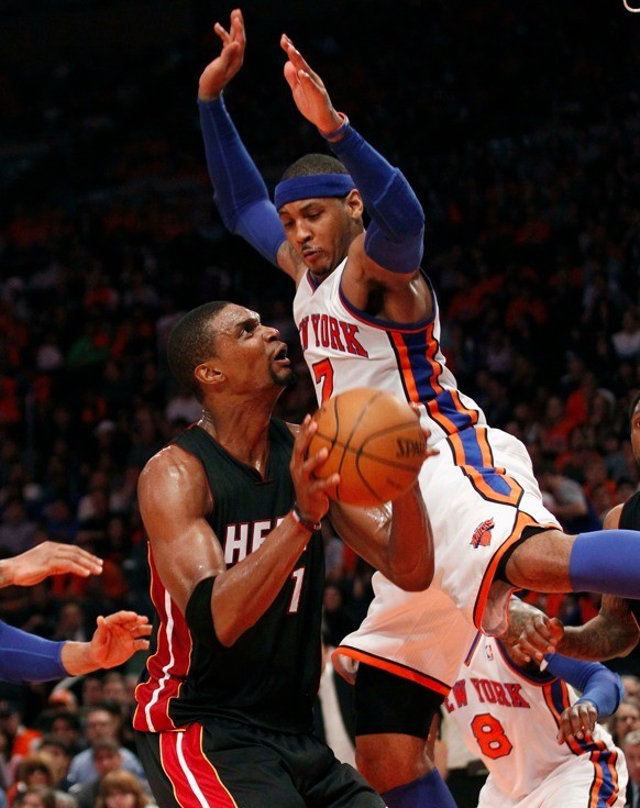 Miami Heat's Chris Bosh (L) fakes New York Knicks' Carmelo Anthony