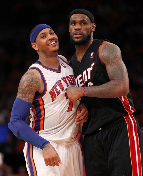 New York Knicks' Carmelo Anthony Smiles as he is tightly defended by Miami Heat's LeBron James in the second half during their NBA basketball game in New York, April 15, 2012. 