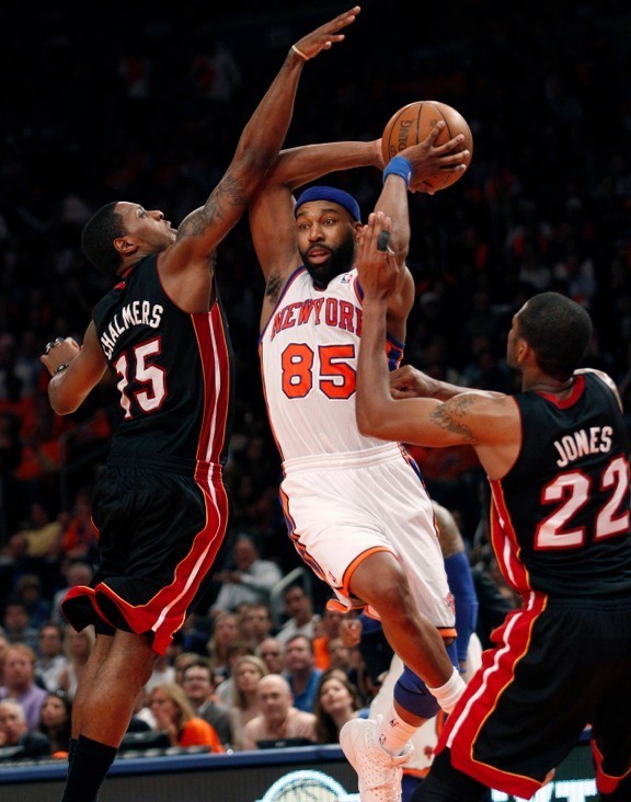 New York Knicks' Baron Davis (85) is defended tightly by Miami Heat's Mario Chalmers (L) and James Jones (R) in the second half During their NBA basketball game in New York, April 15, 2012. 