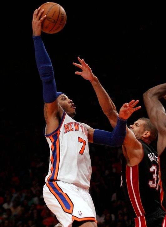 New York Knicks' Carmelo Anthony (L) scores over Miami Heat's Shane Battier in the second half during their NBA basketball game in New York, April 15, 2012. 