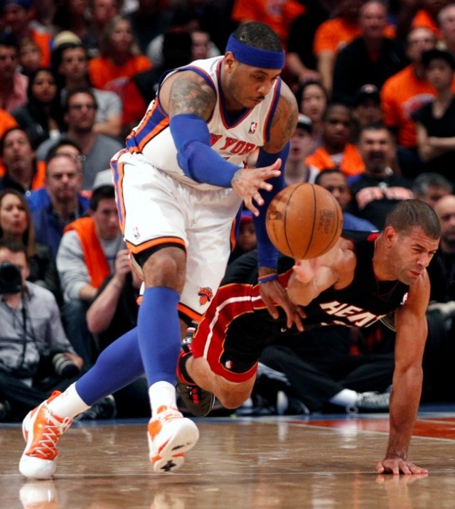 New York Knicks' Carmelo Anthony (L) battles Miami Heat's Shane Battier for a loose ball in the first half during their NBA basketball game in New York, April 15, 2012. 
