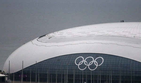 Winter Olympics 2014 Workers stand atop the roof of the Bolshoy