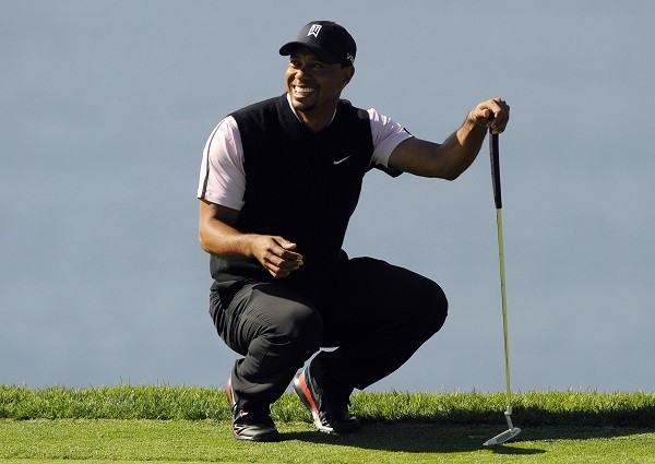Tiger Woods waits to putt on the fourth