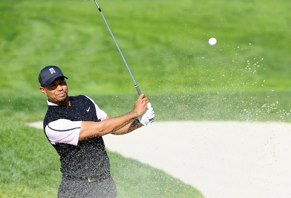Tiger Woods hits the ball out of the bunker on the fifth hole 
