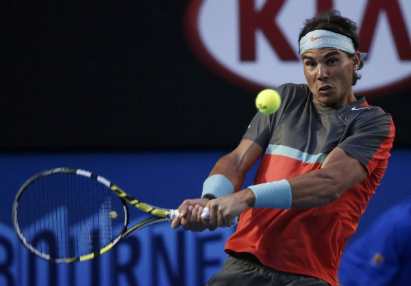 Rafael Nadal of Spain hits a return to Roger Federer