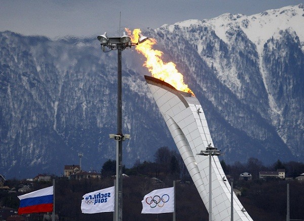 The Olympic flame is tested in its cauldron in front of the Caucasus Mountain in the Adler district of Sochi