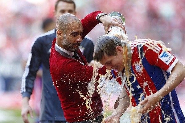 Bayern Munich's coach Josep Guardiola pours a glass of beer over the head of Toni Kroos