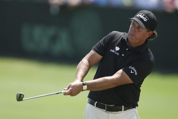 Phil Mickelson chips on the practice green
