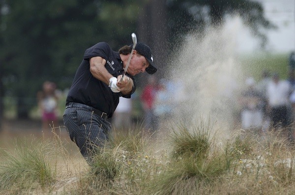 Phil Mickelson of the U.S. hits a shot from the rough on the 12th 