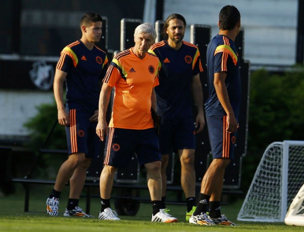 Colombia's national team coach Jose Pekerman walks accompanied by soccer players James Rodriguez