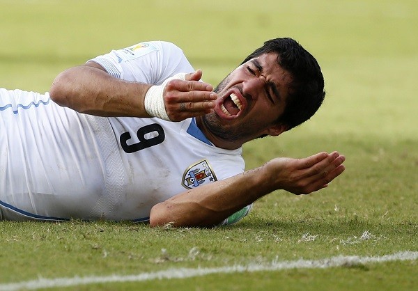 Uruguay's Luis Suarez reacts after clashing with Italy's Giorgio Chiellini 