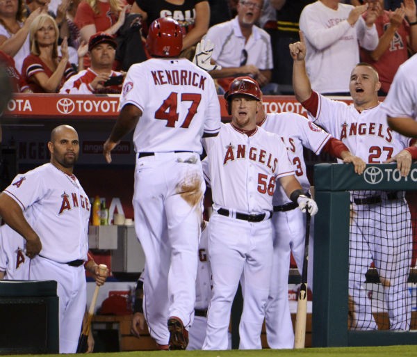 Los Angeles Angels second baseman Howie Kendrick (47) celebrates with teammates Albert Pujols (5) and Kole Calhoun (56) and Mike Trout