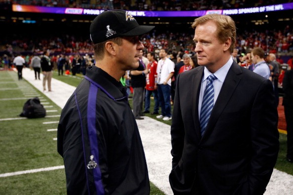 Head coach John Harbaugh (L) of the Baltimore Ravens talks with NFL Commissioner Roger Goodell 