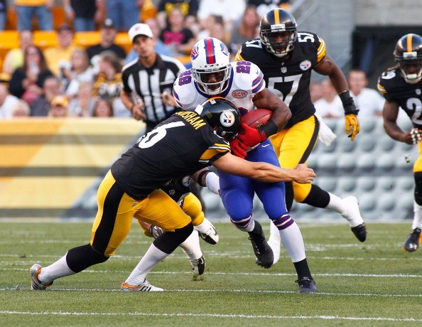 Spiller #28 of the Buffalo Bills is dragged down by Shaun Suisham 