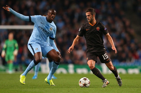 Miralem Pjanic of AS Roma competes with Yaya Toure of Manchester City 