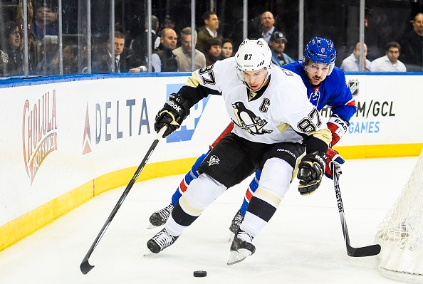 Kevin Klein #8 of the New York Rangers fights for the puck with Sidney Crosby #87 