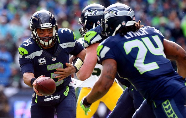 Russell Wilson #3 of the Seattle Seahawks hands the ball off to Marshawn
