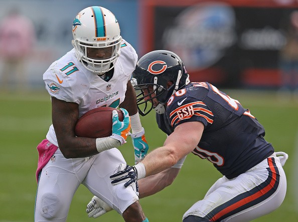 Mike Wallace #11 of the Miami Dolphins is hit by Shea McClellin