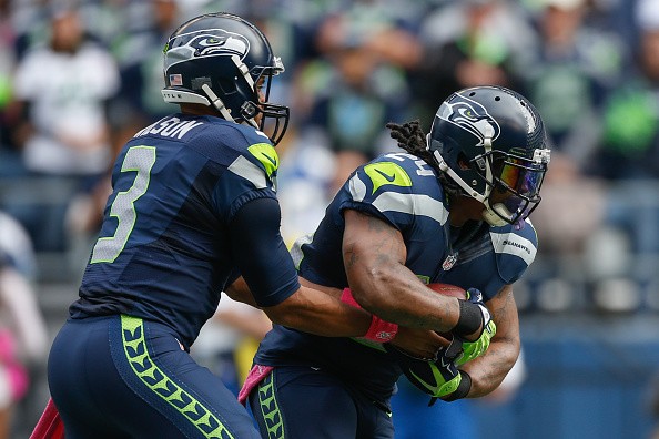 Quarterback Russell Wilson #3 of the Seattle Seahawks hands off to running back Marshawn Lynch