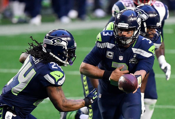 Russell Wilson #3 hands the ball to Marshawn Lynch #24 of the Seattle Seahawks 