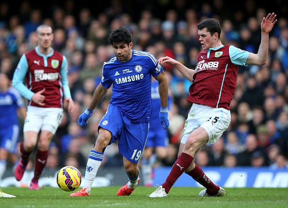 Diego Costa of Chelsea is tackled by Michael Keane 