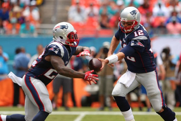 Tom Brady #12 of the New England Patriots hands off to teammate Stevan Ridley