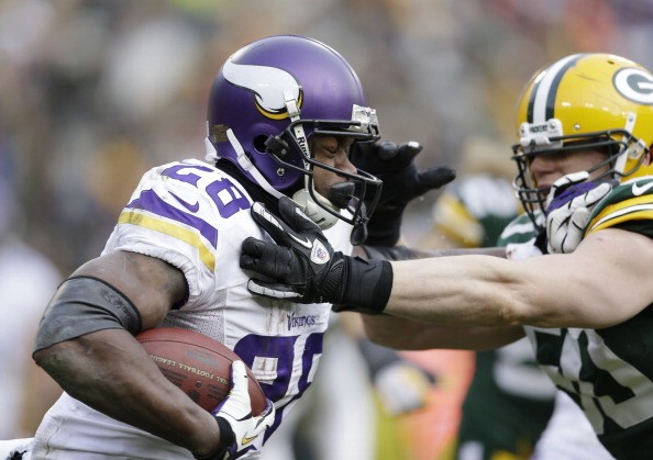 A.J.Hawk #50 of the Green Bay Packers hits Adrian Peterson #28 of the Minnesota Vikings