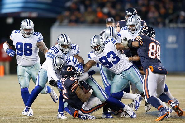 Rolando McClain #55, Anthony Hitchens #59 and Anthony Spencer #93 of the Dallas Cowboys tackle Matt Forte #22 of the Chicago Bears