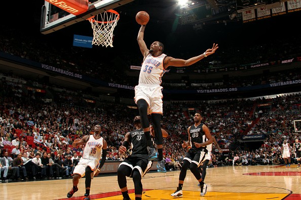 Kevin Durant #35 of the Oklahoma City Thunder dunks against Dwyane Wade #3 of the Miami Heat
