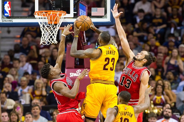 Jimmy Butler #21 and Joakim Noah #13 of the Chicago Bulls try to block LeBron James #23 of the Cleveland Cavaliers