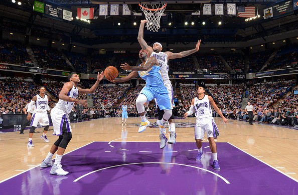 Ty Lawson #3 of the Denver Nuggets shoots a layup against DeMarcus Cousins 