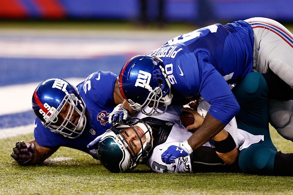 Mark Sanchez #3 of the Philadelphia Eagles is sacked by Jason Pierre-Paul #90 of the New York Giants 