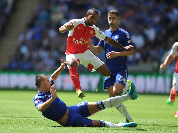 Theo Walcott of Arsenal challenged by John Terry of Chelsea