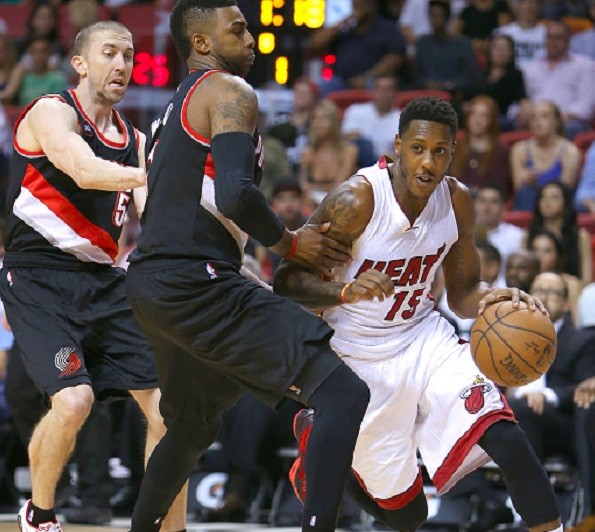 The Miami Heat's Mario Chalmers, right, drives against the Portland Trail Blazers' Steve Blake, left and Dorell Wright