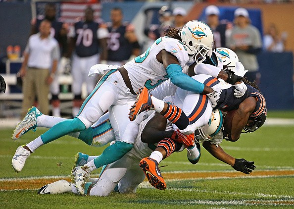 Walt Aikens #35, Kelvin Sheppard #52 and Michael Thomas #31 of the Miami Dolphins