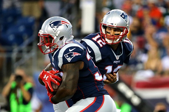 Tom Brady #12 of the New England Patriots hands the ball off to Jonas Gray #35