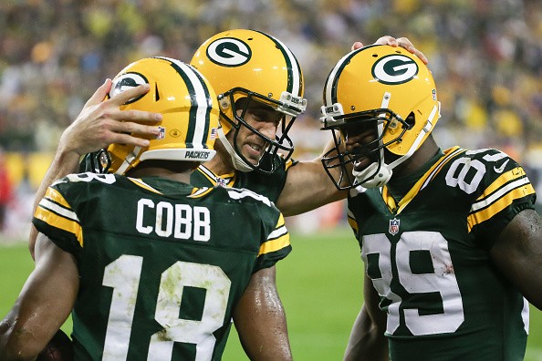 Quarterback Aaron Rodgers #12 of the Green Bay Packers, Randall Cobb #18 and James Jones #89 