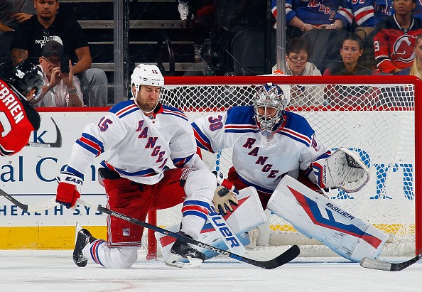Tanner Glass #15 and Henrik Lundqvist #30 of the New York Rangers
