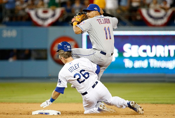 Ruben Tejada #11 of the New York Mets is hit by a slide by Chase Utley #26
