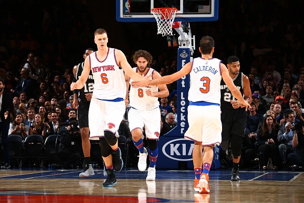 Kristaps Porzingis #6 high fives teammate Jose Calderon #3 of the New York Knicks